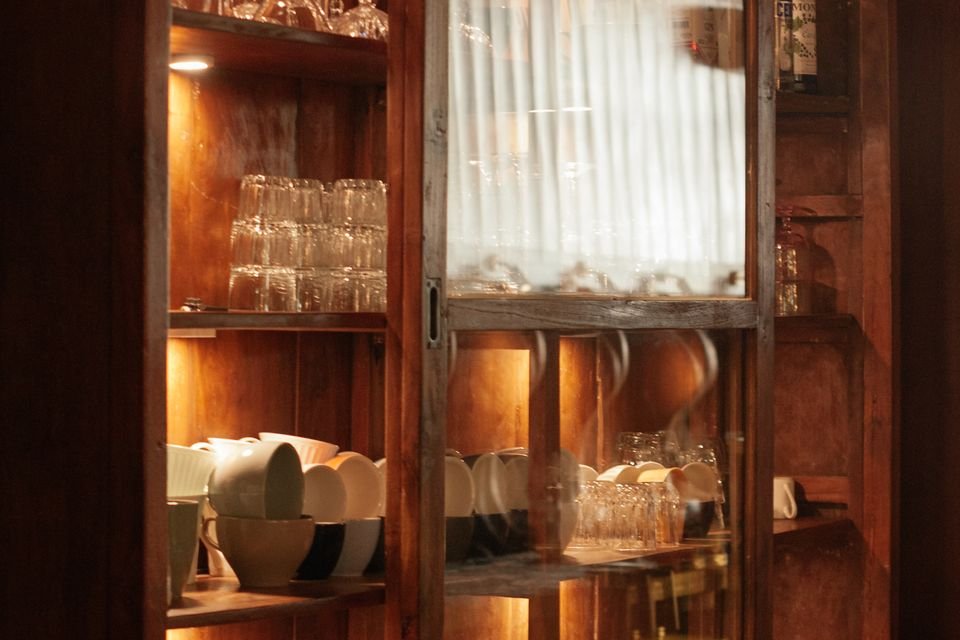 Holzvitrine mit Gläsern, Tassen und Schüsseln